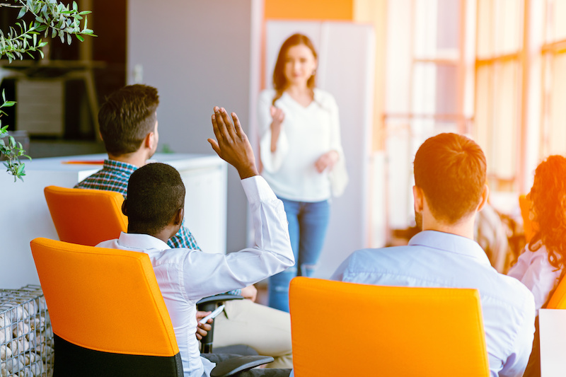 Business people Raising there Hand Up at a Conference to answer a question.