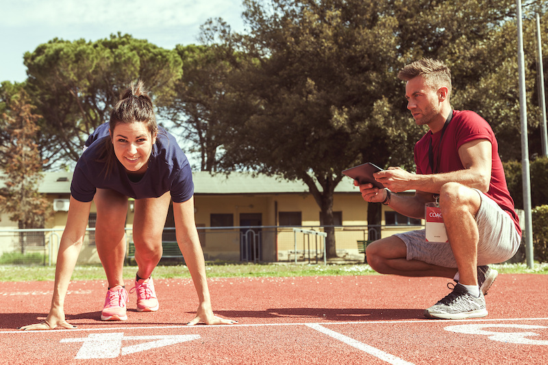 the coach times and gives tips for the ride to his young runner athlete with the tablet