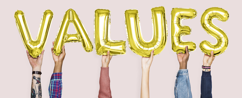 Hands holding values word in balloon letters