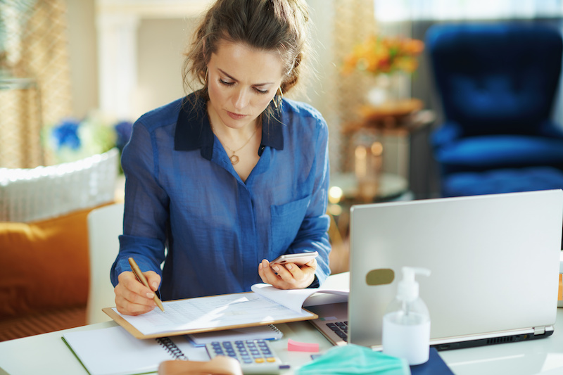 woman in blue blouse in the modern house in sunny day working from home