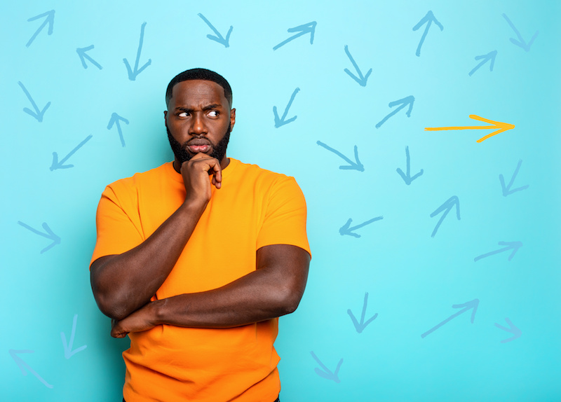 Man have to choose the right arrow to follow. Concept of options, confusion, decision.