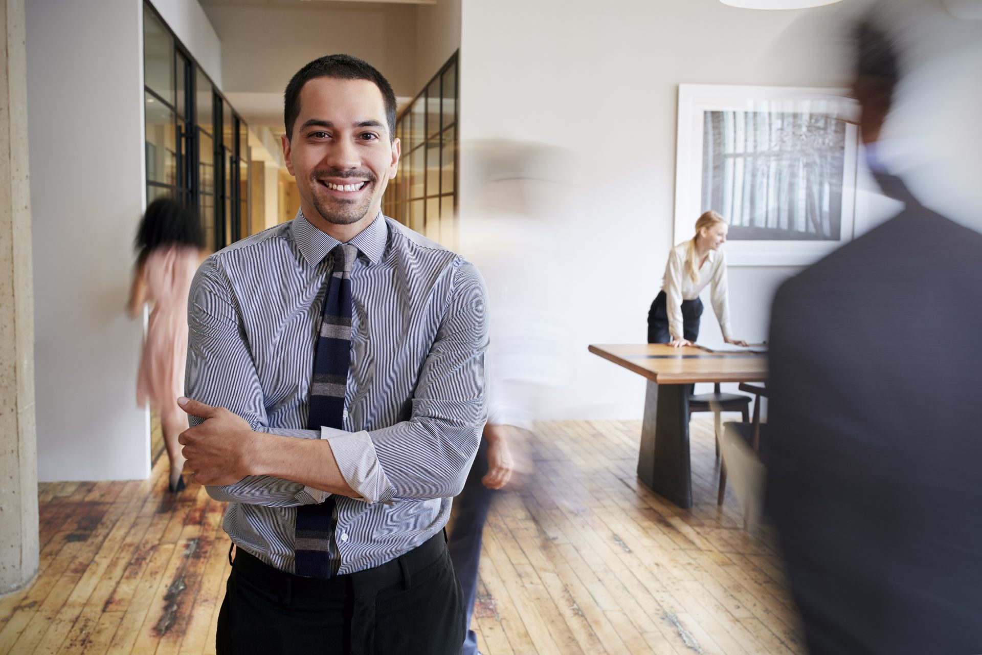 Portrait of young man in a busy modern workplace