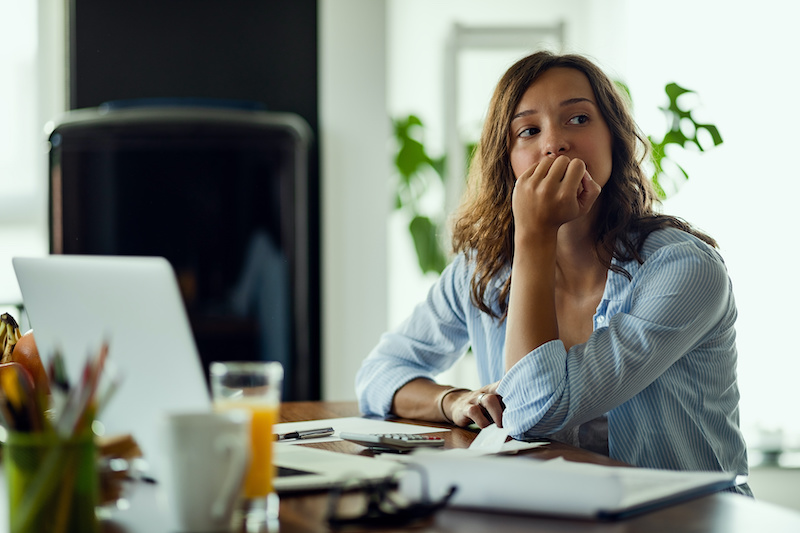 Young worried woman thinking of something while applying for a job