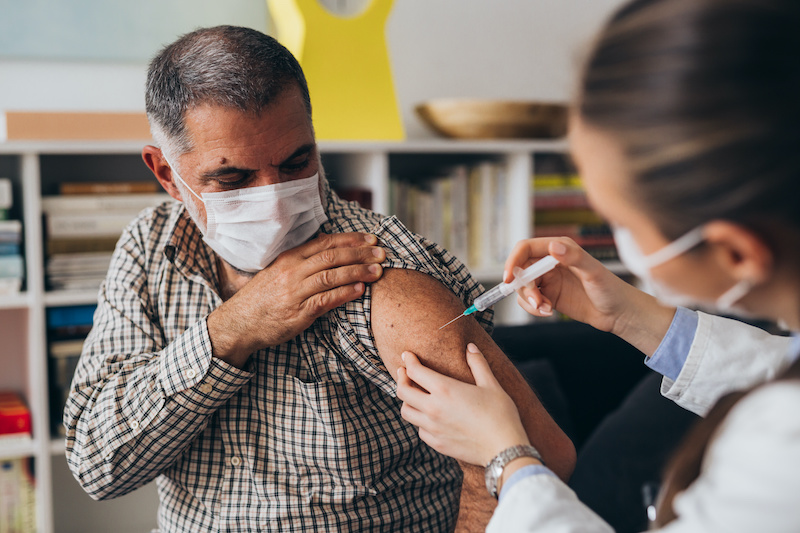 Man employee receiving COVID-19 vaccination